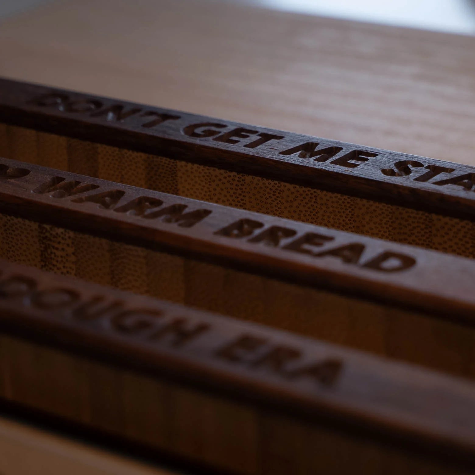 Close-up of engraved sourdough bread knife handles showing the personalized phrase engraving.