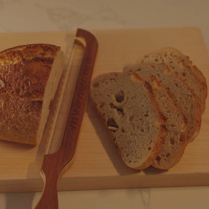 Clean, even slices of sourdough bread cut with a Loreto Studio bread knife on a wooden cutting board.