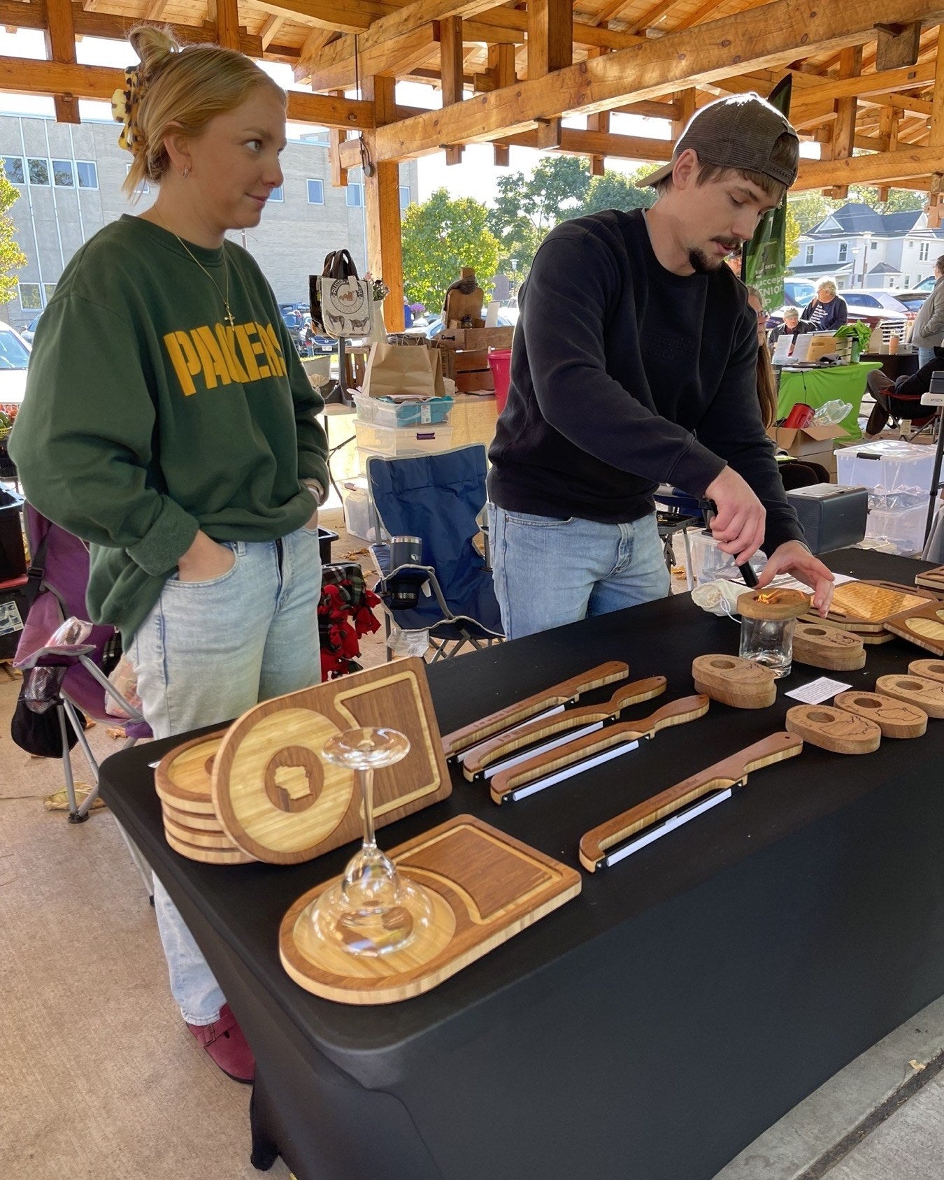 Walker showing products to a customer at the Loreto Studio market booth